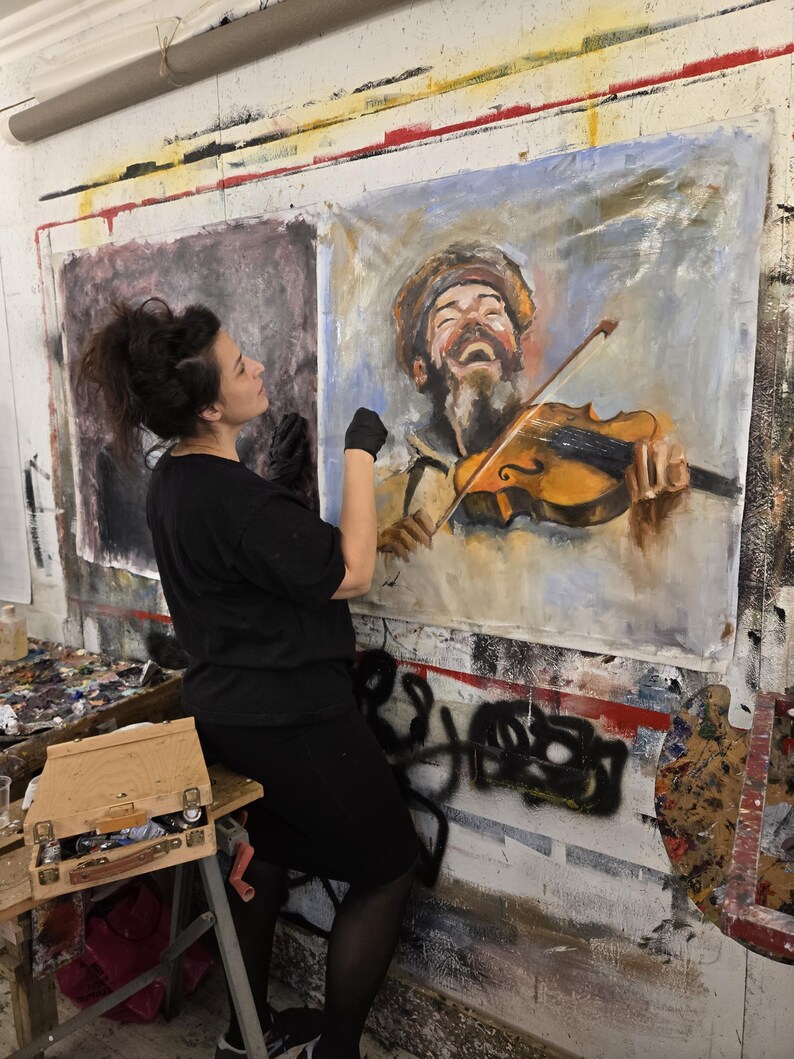 Puede incluir: Una pintura grande sobre lienzo rectangular que presenta el retrato de una persona con barba que lleva un sombrero y toca el viol&iacute;n. La obra utiliza pinceladas expresivas en tonos marrones, amarillos y azules, representando al sujeto con la boca abierta.