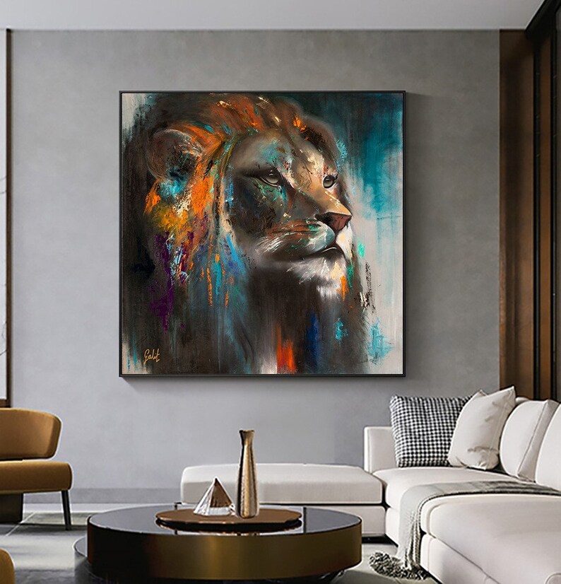 May include: A square wall art painting featuring a lion head in profile, rendered with expressive brushstrokes in shades of dark brown, black, vibrant orange, and teal blue. The artwork displays a signature in the bottom left corner.