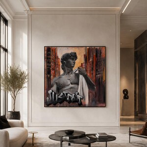 May include: A square wall painting featuring a greyscale bust of a classical male figure draped in white fabric, set against a dark, abstract urban background with red and orange tones. The word JUSTDOIT is written in bold, black graffiti lettering.