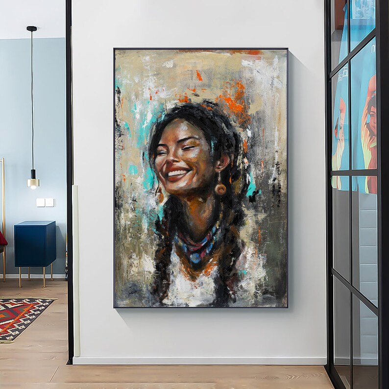 May include: A rectangular wall art piece featuring an oil painting of a smiling person with dark braided hair, wearing earrings and a necklace. The portrait uses textured brushstrokes in shades of brown, white, orange, and turquoise.