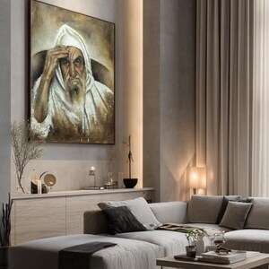 May include: A framed rectangular wall painting depicting an elderly person with a long beard wearing a white hooded garment. The figure has a hand raised to their forehead, rendered in shades of brown, beige, and white with visible brushstrokes.
