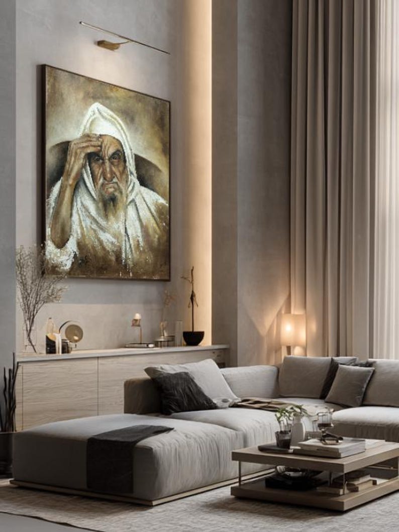 May include: A framed rectangular wall painting depicting an elderly person with a long beard wearing a white hooded garment. The figure has a hand raised to their forehead, rendered in shades of brown, beige, and white with visible brushstrokes.