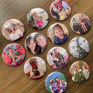 Könnte beinhalten: Eine Sammlung von 11 runden Foto-Knöpfen mit verschiedenen Bildern von Personen und Familien. Die Knöpfe sind weiß mit einem silbernen Rand.