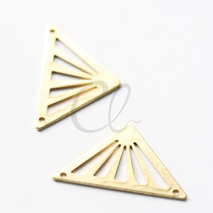 Könnte beinhalten: Zwei goldfarbene Metalldreiecke mit einem ausgeschnittenen Sonnenstrahl-Design. Die Dreiecke sind etwa 5 cm lang.