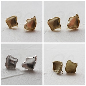 Op de afbeelding: Vier paar oorbellen in verschillende afwerkingen. Twee paar zijn goud, één paar is zilver en één paar is messing. De oorbellen hebben allemaal de vorm van een vierkant met afgeronde hoeken.