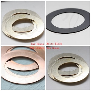 May include: Four metal rings in different finishes: raw brass, raw copper, matte black, and raw brass. The rings are stacked on top of each other.