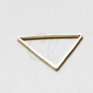 Puede incluir: Un dije de triángulo dorado con un acabado liso y pulido.