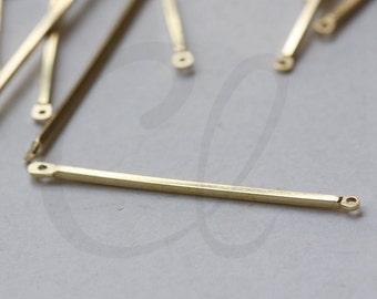 May include: A close-up of a group of gold-colored metal jump rings. The jump rings are all the same size and shape, and they are arranged in a random pattern. The jump rings are made of raw brass.