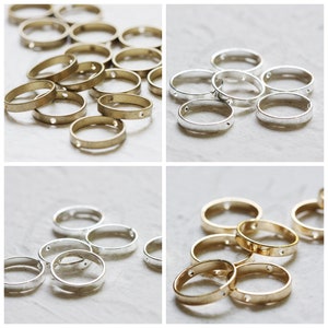May include: A collection of gold and silver metal rings with a hole in the center. The rings are arranged in a circular pattern.