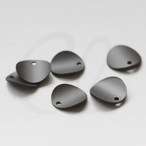 May include: A collection of matte gray teardrop-shaped metal charms. Each charm has a small hole at the top for stringing. The charms are scattered on a white surface, showcasing their smooth, curved design.