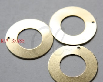 May include: Three gold-colored metal rings with a hole in the center. The rings are flat and have a smooth surface. The text "RAW BRASS" is visible in the image.