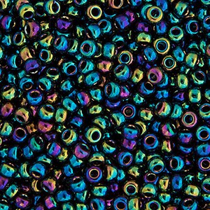 Op de afbeelding: Een close-up van een grote hoeveelheid iriserende zwarte zaadkraaltjes. De kralen hebben een metallic glans en reflecteren een verscheidenheid aan kleuren, waaronder blauw, groen en paars.