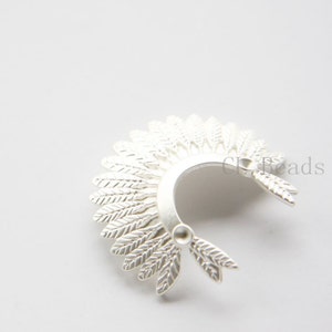 May include: Silver feather headdress charm for jewellery making. The charm is shaped like a headdress with feathers on the sides. It is a great addition to necklaces, bracelets and earrings.