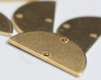 May include: A set of five brass half-circle shapes with holes drilled through them. The shapes are arranged in a fan-like pattern.