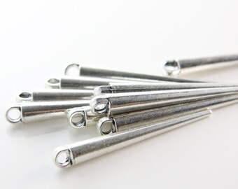 May include: A group of silver metal, pointed, cone-shaped pendant charms with a loop at the top.