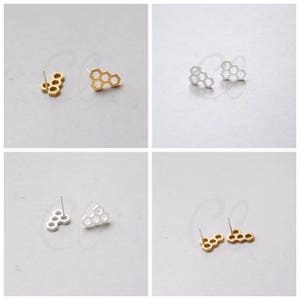 May include: Two pairs of honeycomb-shaped earrings, one pair in gold and one pair in silver.