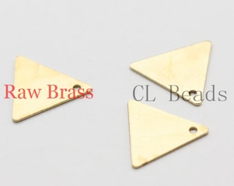 Pode incluir: Três pingentes de metal de forma triangular dourados com um furo no topo. Os pingentes estão sobre uma superfície branca. O texto "Raw Brass" e "CL Beads" é visível na imagem.