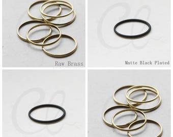 May include: A set of six gold-toned rings, some are stacked on top of each other. The rings are shown in two different finishes: raw brass and matte black plated.