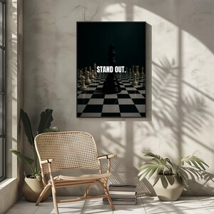 Könnte beinhalten: Gerahmter Druck mit dem Text "STAND OUT" über einem Schachbrett. Ein schwarzer König steht im Zentrum, umgeben von weißen Figuren. Das Bild hat einen dunklen Hintergrund und ist schwarz gerahmt.