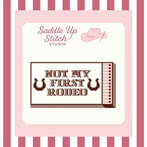 May include: A cross-stitch design with the text "NOT MY FIRST RODEO" in a pixelated font, flanked by horseshoe graphics. The design is set against a light pink background with a pink cowboy hat and the words "Saddle Up Stitch Studio".
