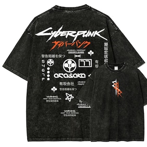 May include: Black acid wash t-shirts with "Cyberpunk" and Japanese text graphics. The back of the shirt features a large design with text and symbols, while the front has a smaller, stylized graphic.