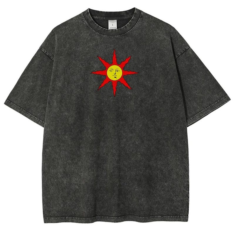 May include: Dark gray t-shirt featuring a stylized sun graphic with a yellow face and red rays. The shirt has a vintage, washed appearance and a classic crew neck design. A casual, unisex tee.