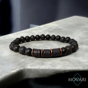 May include: Black lava rock and onyx bead bracelet with copper accents. The bracelet is made of natural stones and is designed for men or women.