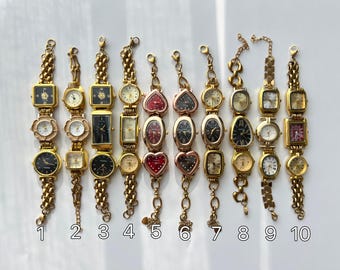 May include: A collection of ten vintage gold-toned wristwatches with various face shapes, including square, rectangular, oval, and heart. Each watch features a different colored face and is attached to a gold chain bracelet. The watches are numbered 1 through 10.