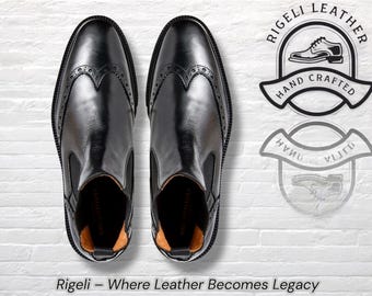 Könnte beinhalten: Paar schwarze Chelsea-Stiefel aus Leder mit Brogue-Details. Die Stiefel haben eine polierte Oberfläche und sind auf einer weißen Backsteinmauer abgebildet. Das Bild enthält den Text "Rigeli - Where Leather Becomes Legacy".