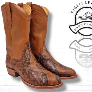 Może przedstawiać: Para brązowych skórzanych butów kowbojskich z cholewkami ze wzorem skóry węża. Buty mają klasyczny design ze spiczastym noskiem i obcasem. Obraz zawiera tekst "RIGELI LEATHER HAND CRAFTED".