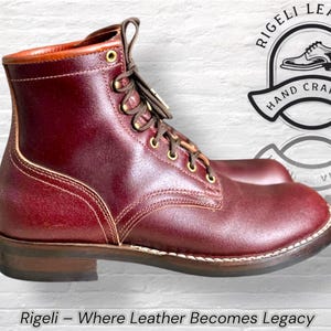 Puede incluir: Bota de cuero burdeos con punta redonda y tac&oacute;n bajo. La bota tiene cierre de cordones con ojales de lat&oacute;n y ribete cosido. Las palabras "Rigeli - Where Leather Becomes Legacy" est&aacute;n en la parte inferior de la imagen.