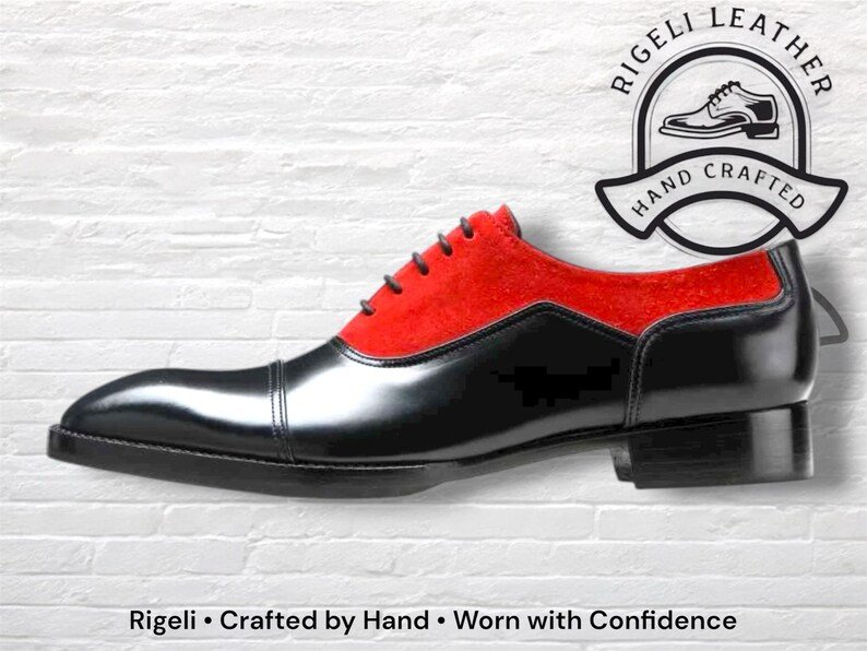 May include: A black and red leather dress shoe with a cap toe and a low heel. The shoe has a red suede upper and black leather on the toe and sides. The shoe is hand crafted. The text "Rigeli Leather" and "Hand Crafted" are in the image.