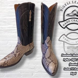 May include: Pair of handmade western boots. The boots feature a black leather upper with decorative stitching and a python-style leather foot. The boots have a pointed toe and a stacked heel. The brand logo is visible.