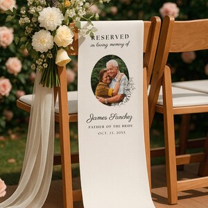 May include: A white fabric memorial sign draped over a wooden chair, featuring the text RESERVED in loving memory of, a circular photograph of two people, and the name James Sanchez, FATHER OF THE BRIDE, OCT. 13, 20XX, with a floral bouquet.
