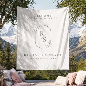 May include: A white wedding banner with the text "WELCOME TO THE WEDDING OF" above the names "RICHARD & STACY" and the date "OCTOBER 12, 20XX". The banner has a floral design with the initials "R/S".