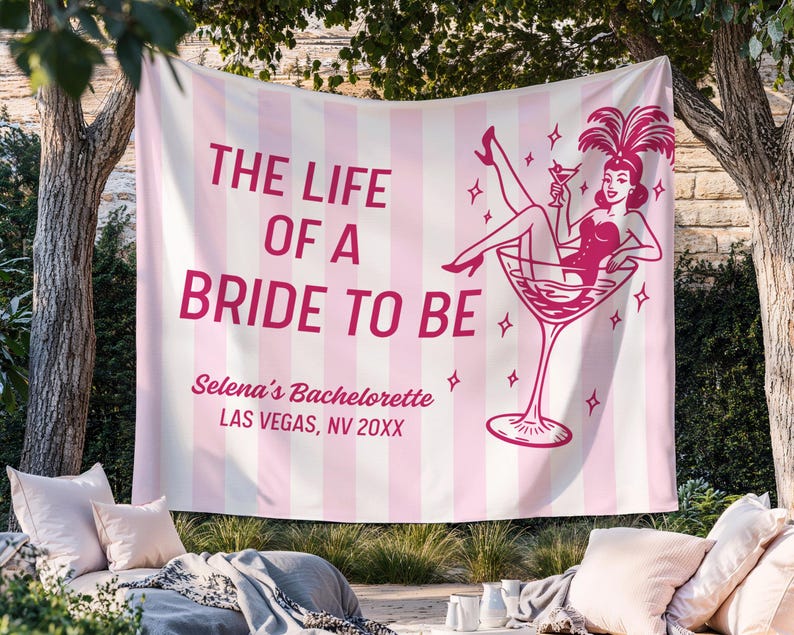 May include: A pink and white striped banner with the text "THE LIFE OF A BRIDE TO BE" in pink. The banner features a graphic of a woman in a martini glass. The banner also includes the text "Selena's Bachelorette LAS VEGAS, NV 20XX".