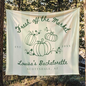 Może przedstawiać: Kremowy baner z pionowymi paskami i zielonym tekstem. Na banerze widnieje napis "Fresh off the Market" nad trzema ilustracjami dyni. Poniżej napis "Louisa's Bachelorette" i "Scottsdale, AZ".