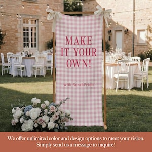 Puede incluir: Un letrero con marco de madera con un patr&oacute;n de cuadros rosa y blanco. El letrero dice "MAKE IT YOUR OWN!" con "with NorahPrints" debajo. El letrero est&aacute; decorado con lazos blancos y est&aacute; colocado al aire libre con mesas y sillas al fondo.