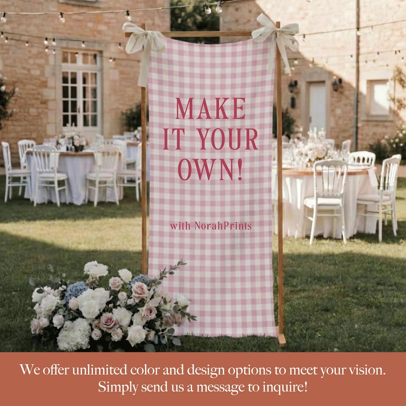Puede incluir: Un letrero con marco de madera con un patr&oacute;n de cuadros rosa y blanco. El letrero dice "MAKE IT YOUR OWN!" con "with NorahPrints" debajo. El letrero est&aacute; decorado con lazos blancos y est&aacute; colocado al aire libre con mesas y sillas al fondo.