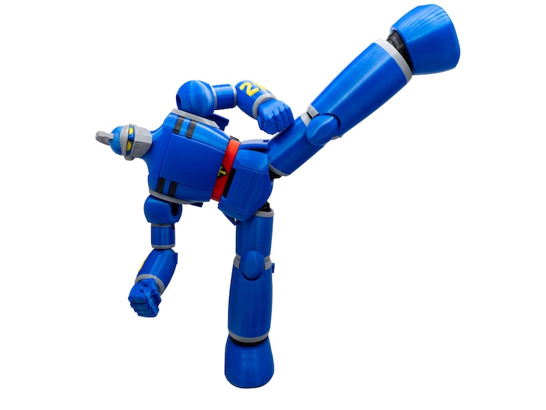 May include: A blue robot action figure with articulated joints, striking a dynamic pose. The figure has a red belt, gray accents, and the number "2" on its shoulder. The robot is set against a plain white background.