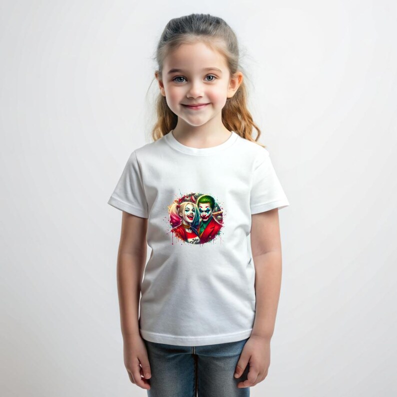 May include: White t-shirt with a colourful graphic of Harley Quinn and the Joker. The design is a vibrant splash of colours, with the characters' faces prominently displayed. The shirt is worn by a young person.