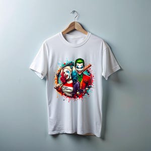 May include: White t-shirt with a colourful graphic of Harley Quinn and the Joker, each holding a baseball bat. The design includes vibrant splashes of colour and the text "Harley & Suicide".