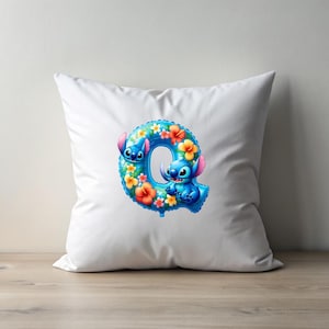 Puede incluir: Almohada blanca con una letra Q azul y floral con los personajes de Stitch de la pel&iacute;cula de Disney Lilo & Stitch.
