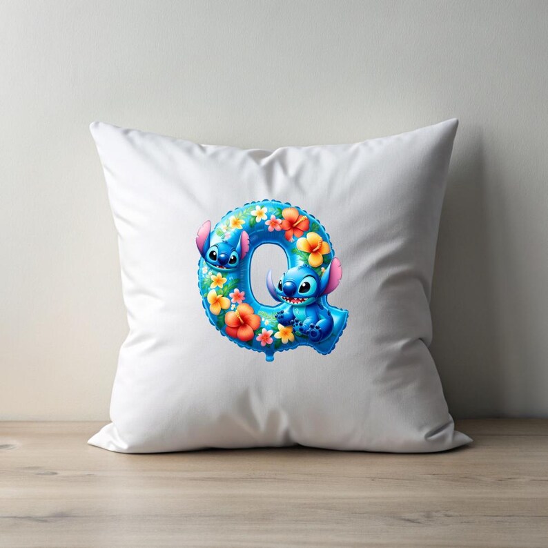Puede incluir: Almohada blanca con una letra Q azul y floral con los personajes de Stitch de la pel&iacute;cula de Disney Lilo & Stitch.