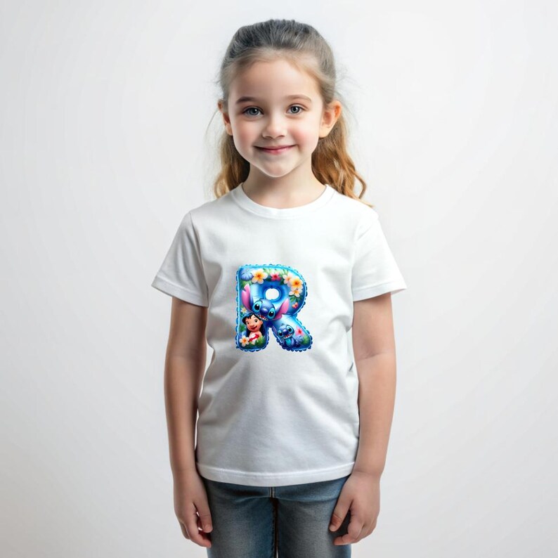 Puede incluir: Camiseta blanca con una letra R azul y rosa con Stitch y Angel de Lilo & Stitch. La letra est&aacute; rodeada de flores.