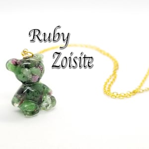 May include: A green and pink teddy bear charm necklace made with ruby zoisite. The necklace has a gold chain.