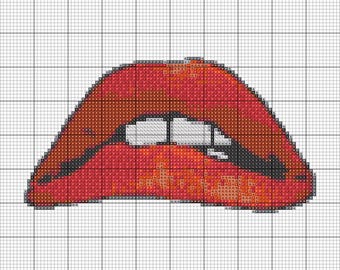 May include: Cross-stitch pattern of a pair of red lips with white teeth and black outlines. The design is on a grid background, suggesting a craft project or embroidery pattern.