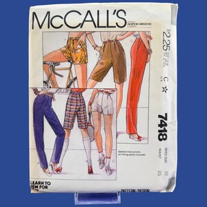 May include: A McCall's sewing pattern envelope, number 7418, featuring illustrations of various pants and shorts styles. The cover displays six different garment designs in colors including orange, brown, red, blue, and plaid, with text.