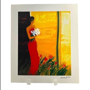 May include: An art print featuring a woman in a red dress holding white flowers. The background is a vibrant mix of yellow and orange, with a touch of green. The print is signed in the bottom right corner.