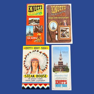 May include: Four vintage Knott's Berry Farm brochures featuring colorful graphics and text. One shows a person in a feathered headdress, another depicts Independence Hall, a third displays a restaurant menu, and the fourth highlights Ghost Town.